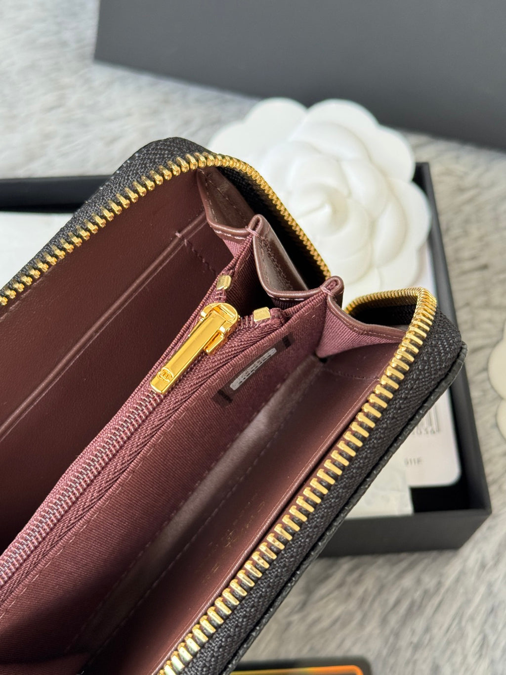 Small crossbody bag with maroon interior and gold zipper, dark exterior trim