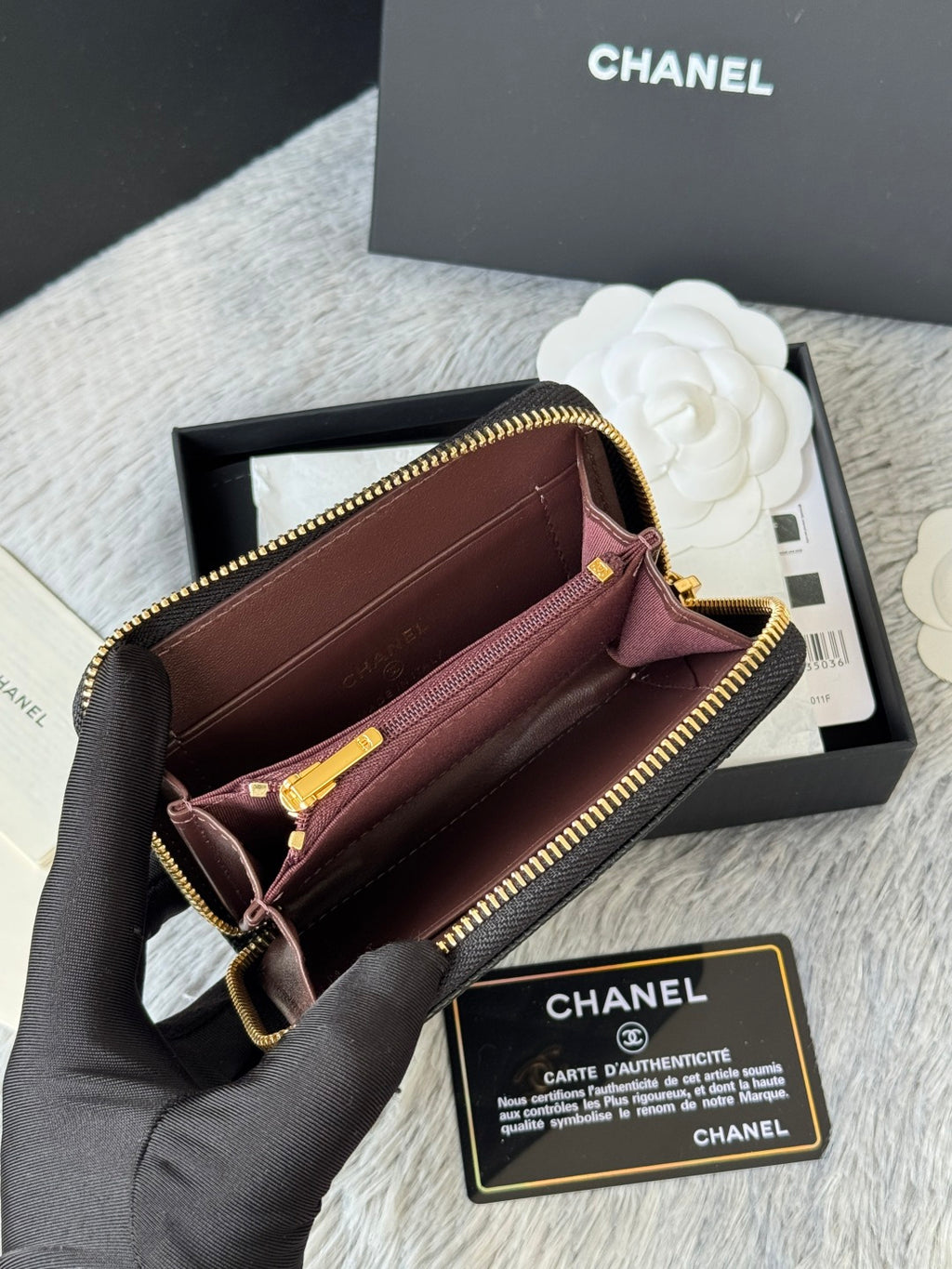 Small bag with open top, black exterior and pink interior, gold zipper