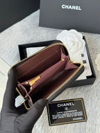Small bag with open top, black exterior and pink interior, gold zipper
