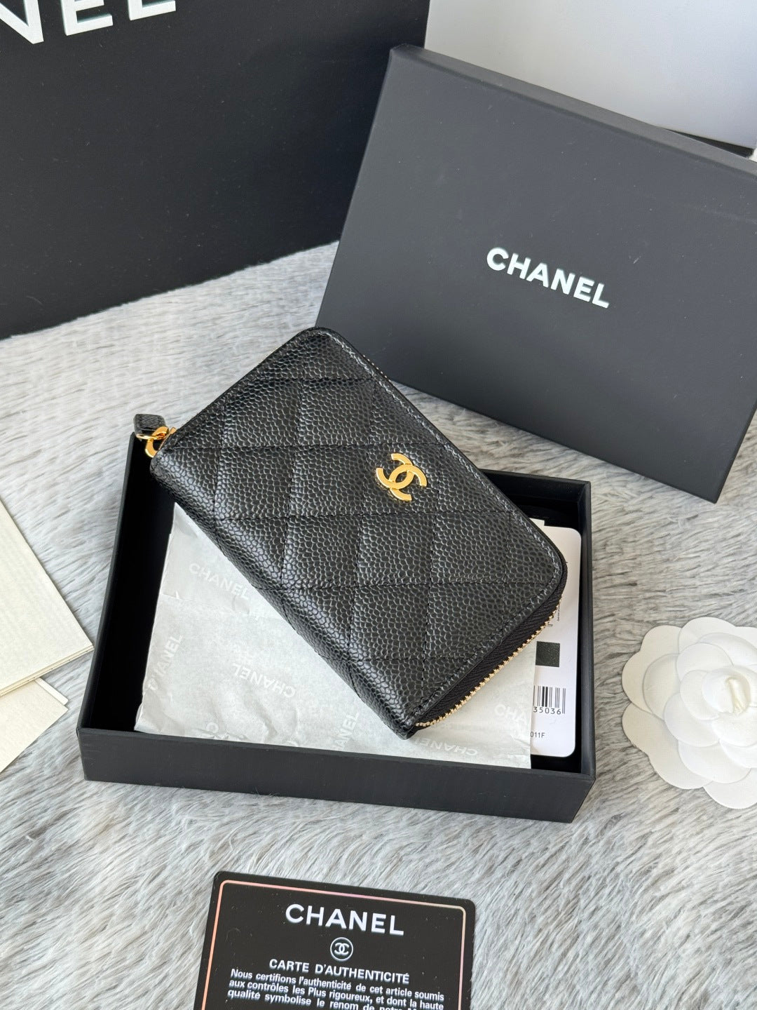 Small leather zip pouch, black with gold Chanel emblem and textured quilt pattern