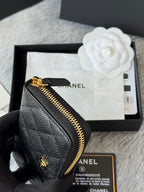 Small black leather bag with gold zipper, showing interior card slot