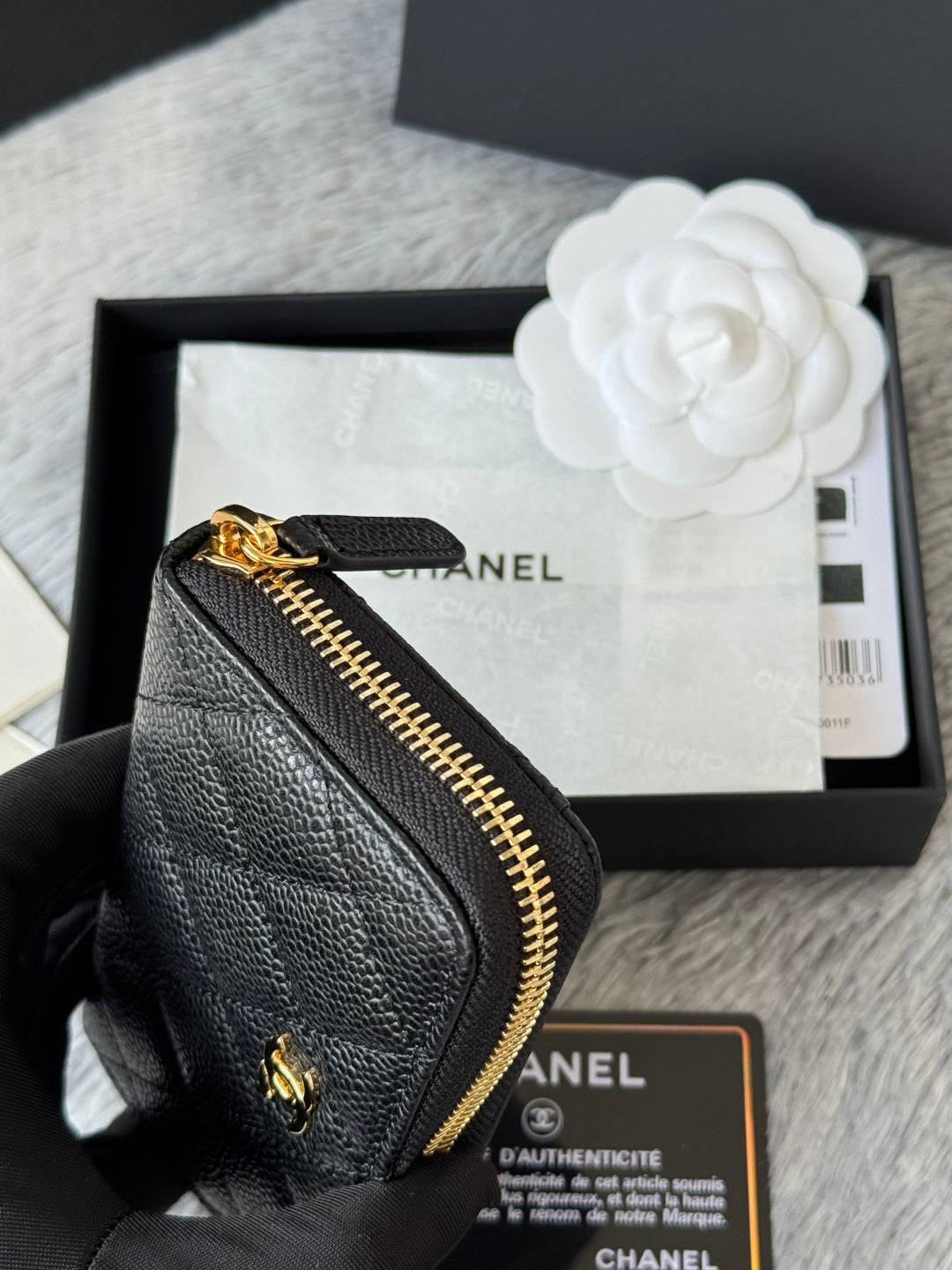 Small black leather bag with gold zipper, showing interior card slot