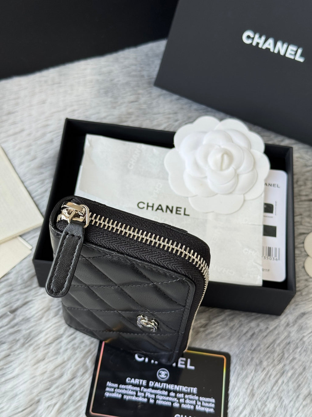 Small bag: black quilted zip pouch with CHANEL logo, side view