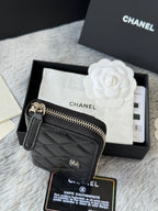 Small bag: black quilted zip pouch with CHANEL logo, side view