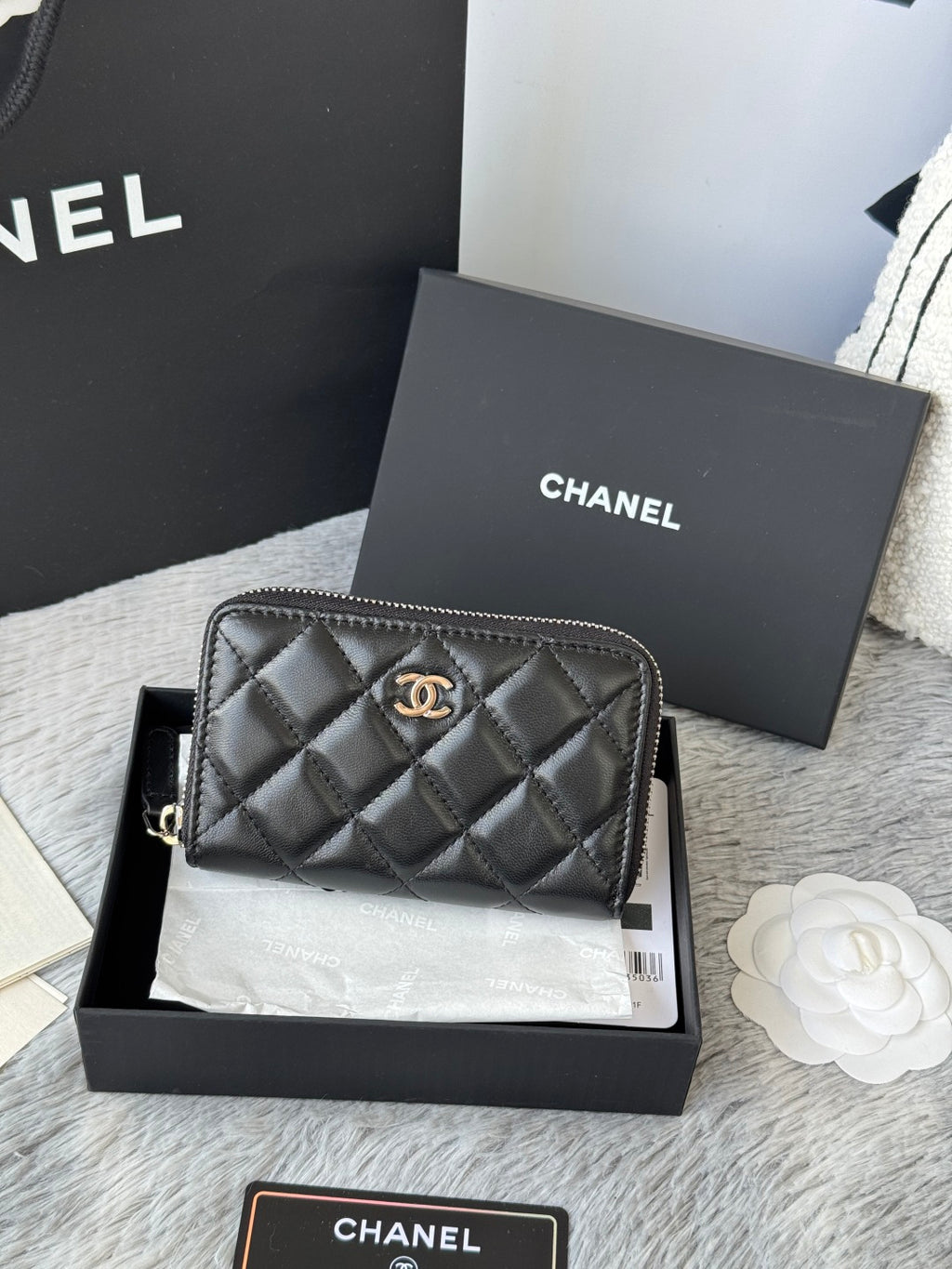 Small bag: black quilted zip pouch, front view with CHANEL logo