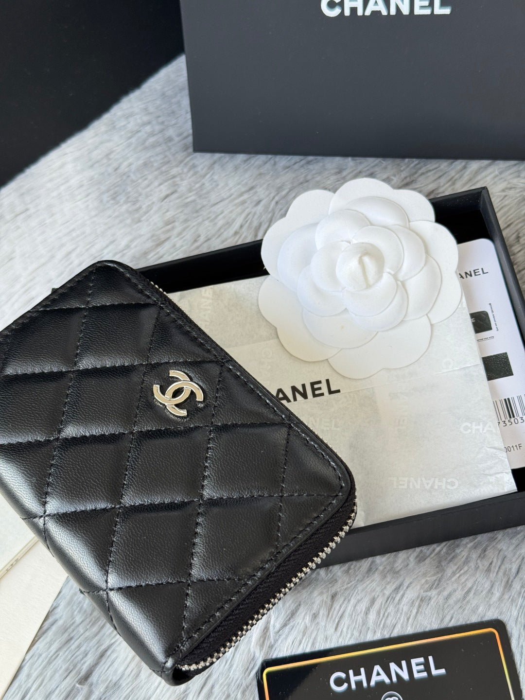 Small bag: black quilted zip pouch with CHANEL logo, close-up