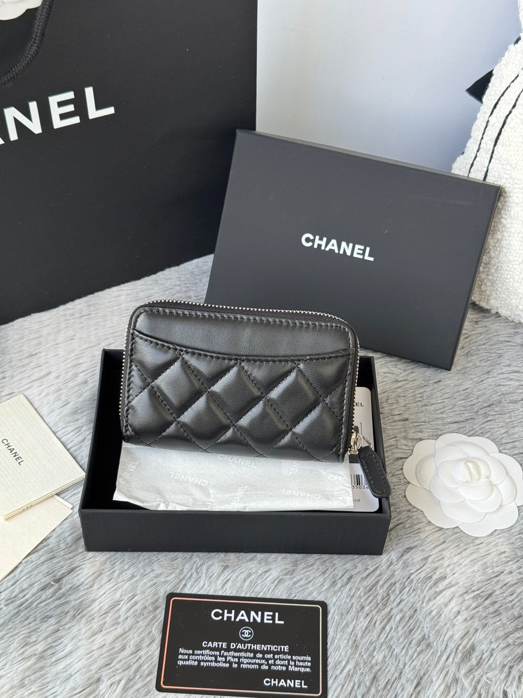 Small bag: black quilted zip pouch, side angle with CHANEL logo