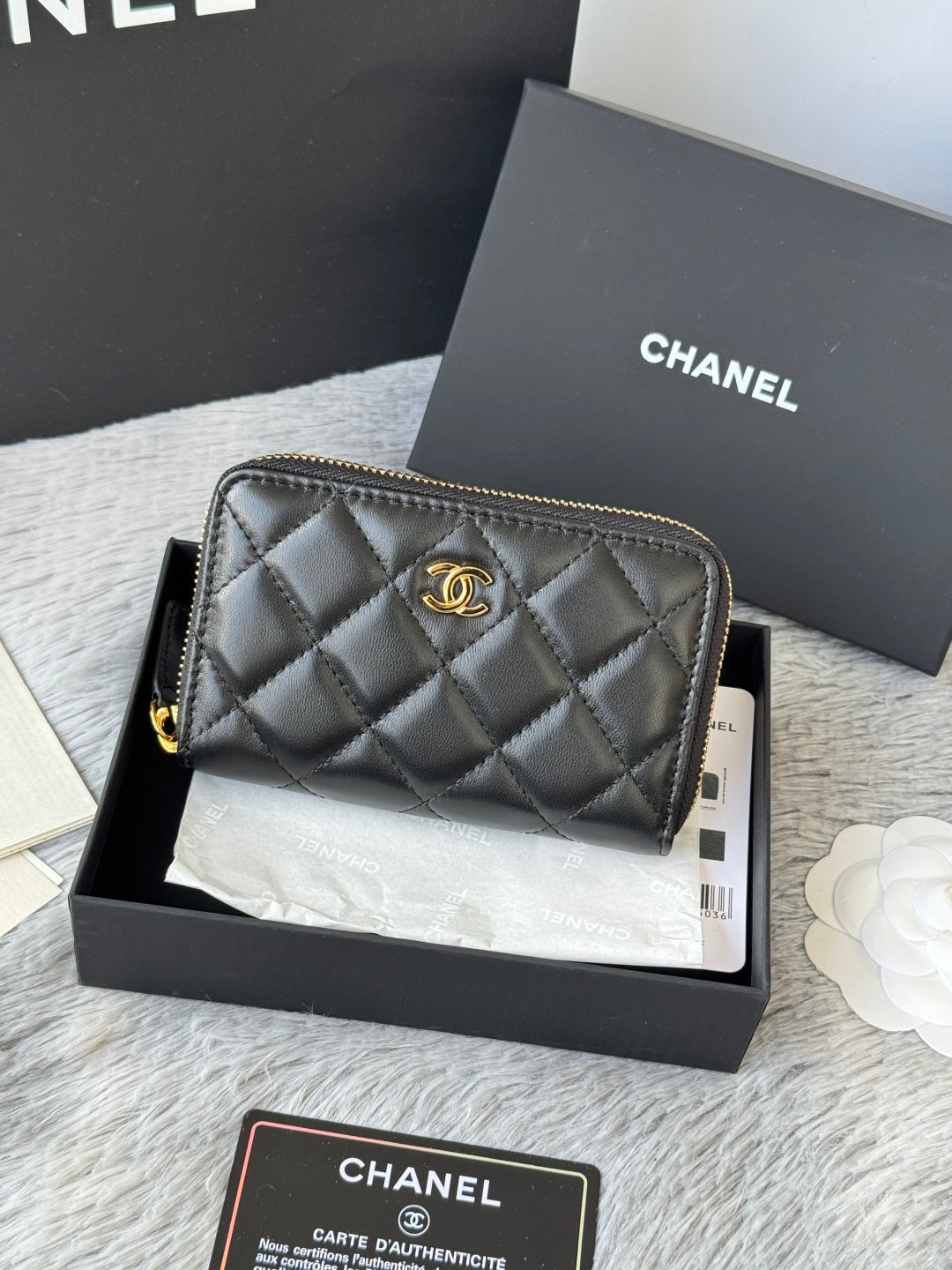 Small quilted zip wallet, dark leather with gold-tone logo and zipper pull