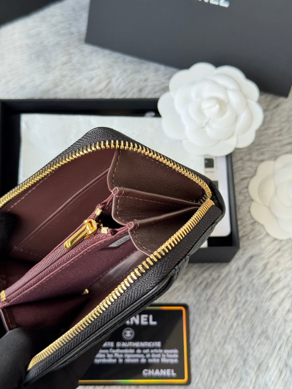 Burgundy small bag interior view, gold-tone zipper edge, black strap, hanging charm