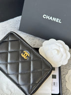 Small quilted zip wallet close-up, dark leather with gold-tone logo badge