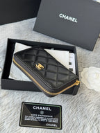 Small quilted zip wallet, dark leather with gold-tone zipper and logo charm