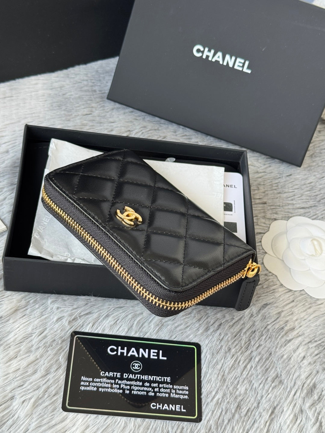 Small quilted zip wallet, dark leather with gold-tone zipper and logo charm