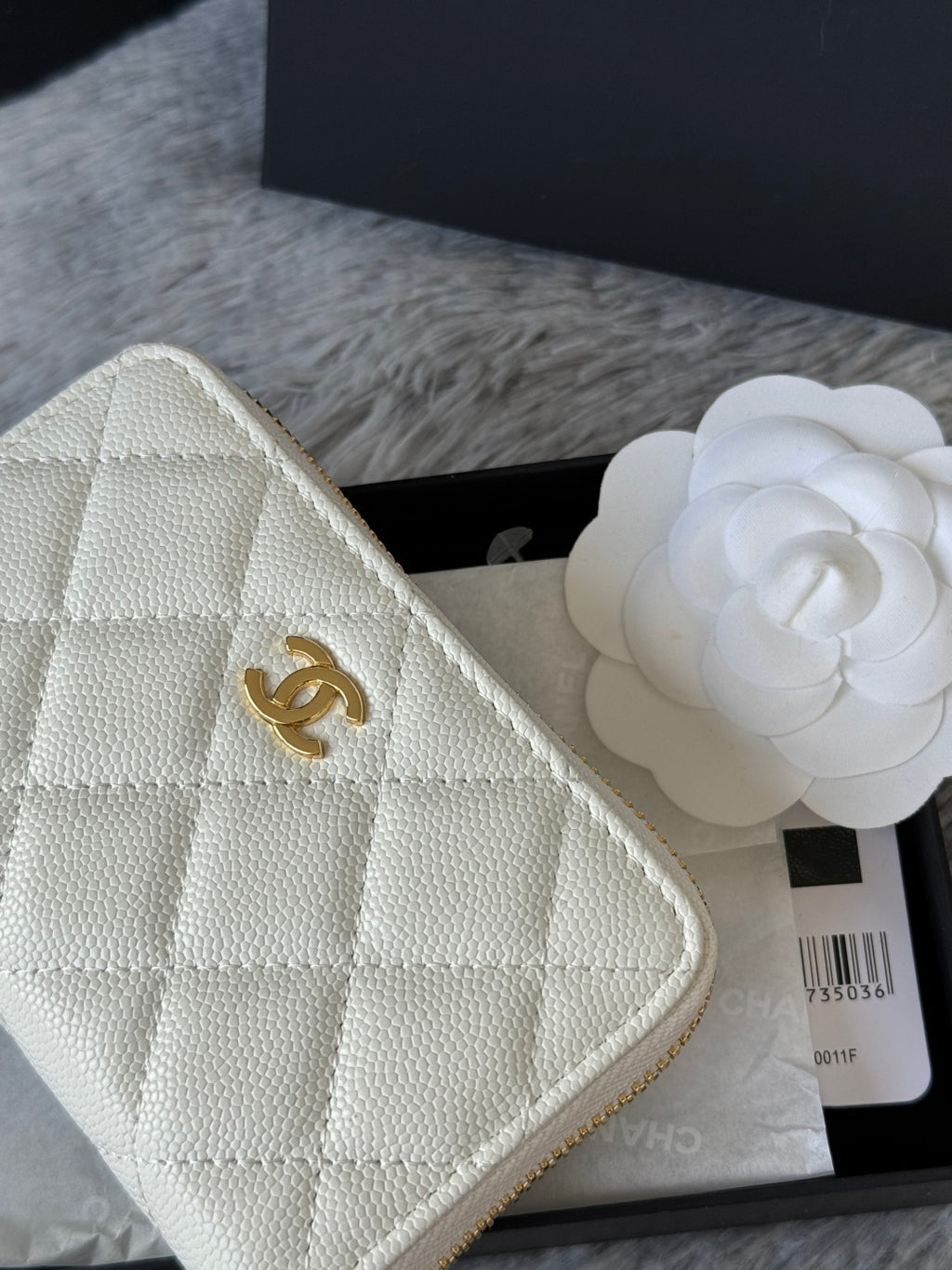 White quilted small bag close-up with CC logo and textured leather-like finish