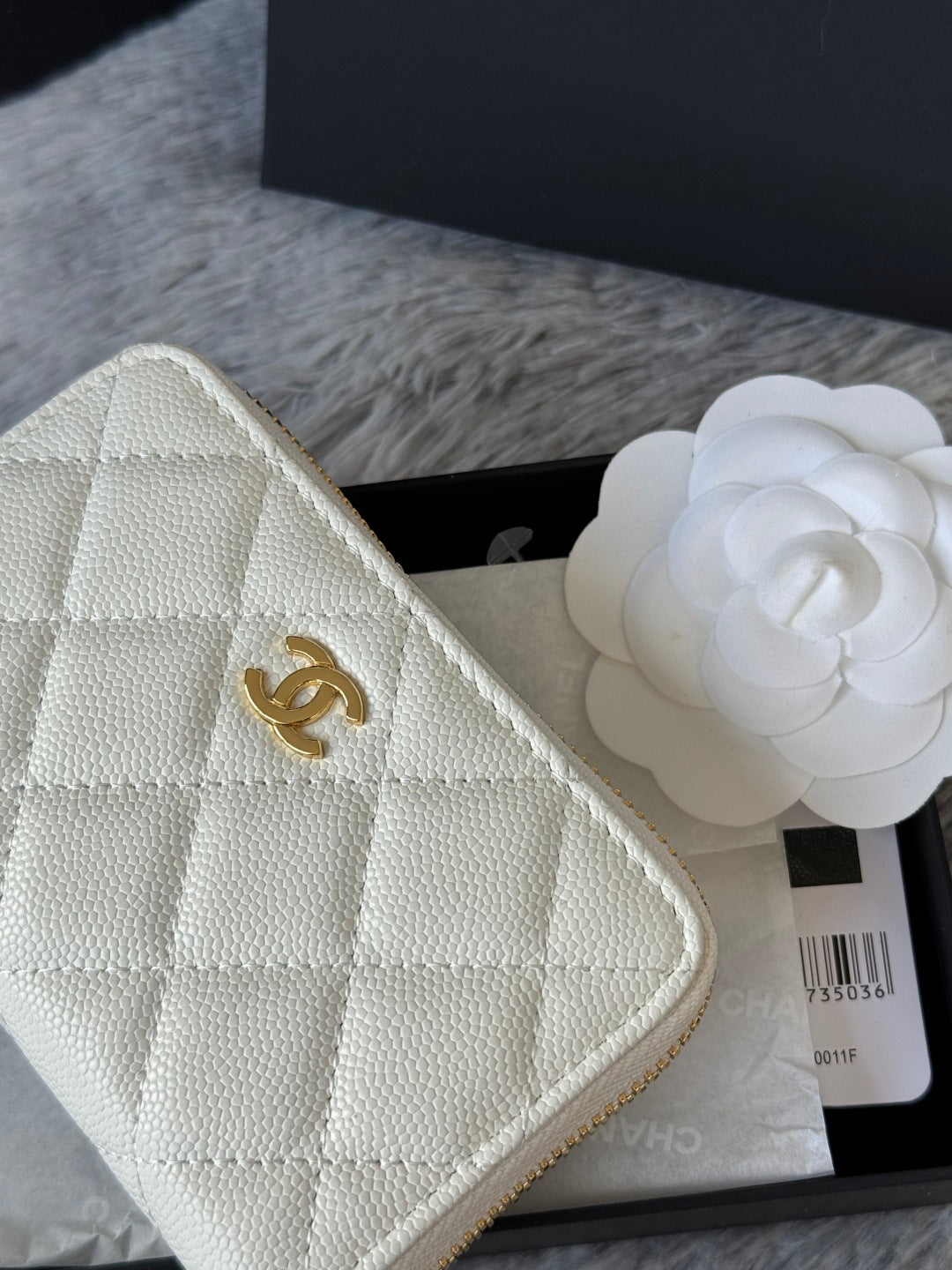 White quilted small bag close-up with CC logo and textured leather-like finish