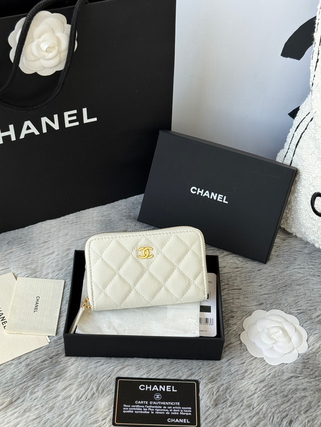 White quilted small bag with gold chain strap, CC logo, and zip closure