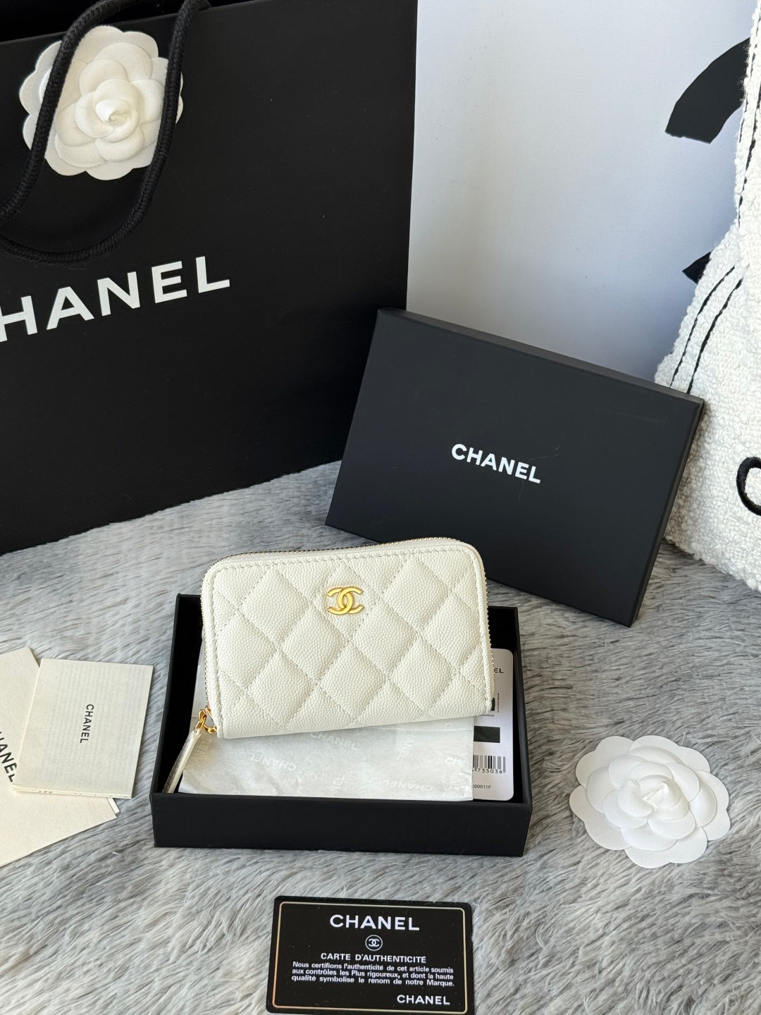 White quilted small bag with gold chain strap, CC logo, and zip closure