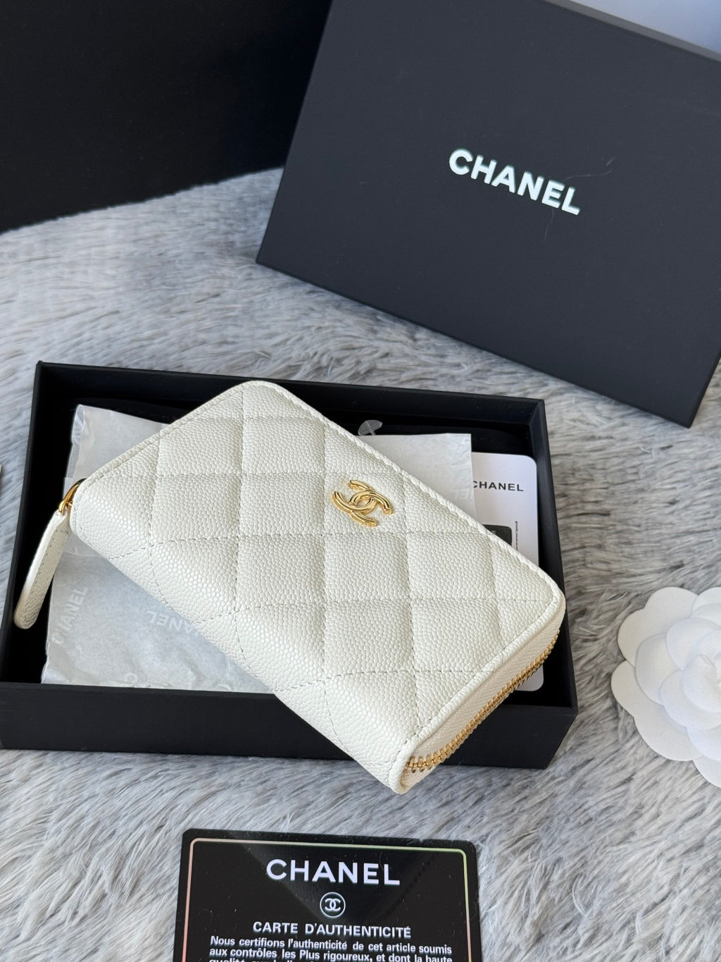 White quilted small bag with CC logo, gold zipper trim, and wristlet strap