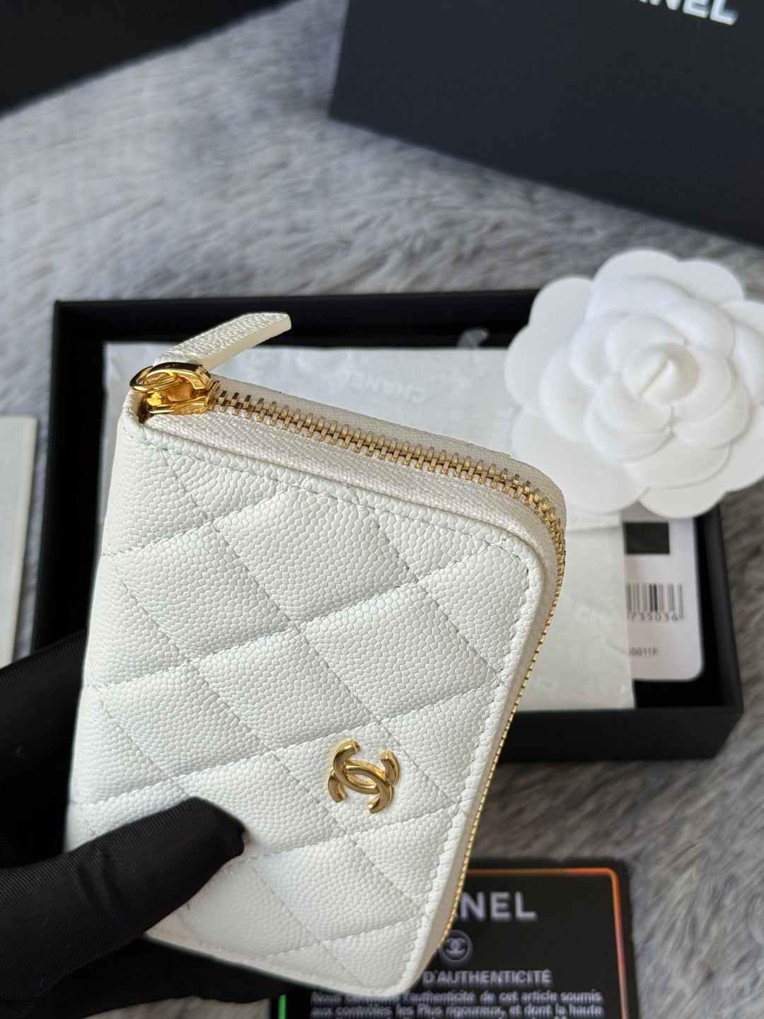 White quilted small bag close-up with gold zipper and gold CC logo hardware