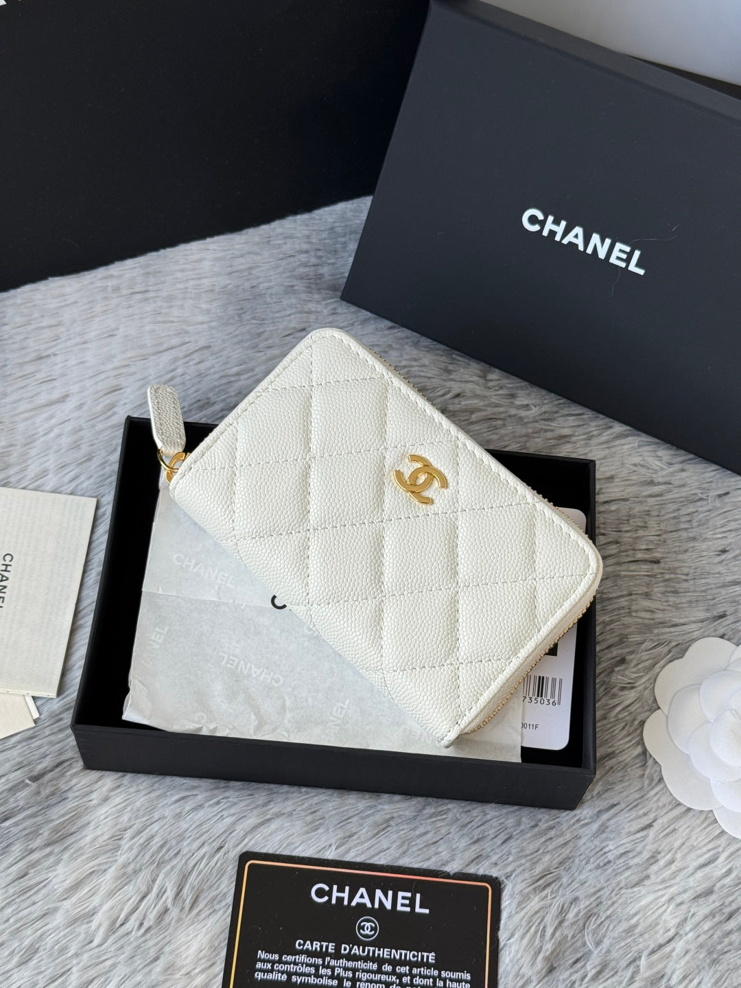 White quilted small bag with CC logo and gold zipper, with wrist strap attached