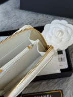 Beige interior of white quilted small bag with gold zipper and hardware close-up