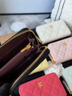 Small quilted zip wallet open view showing dark interior, credit-card slots, and zippers.