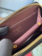 Small quilted zip wallet interior with CHANEL branding and gold zipper trim, brown lining.