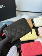 Small quilted zip wallet in textured black leather with gold zipper pull and CC logo.