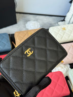 Small quilted zip wallet in textured black leather with centered gold CC logo front.