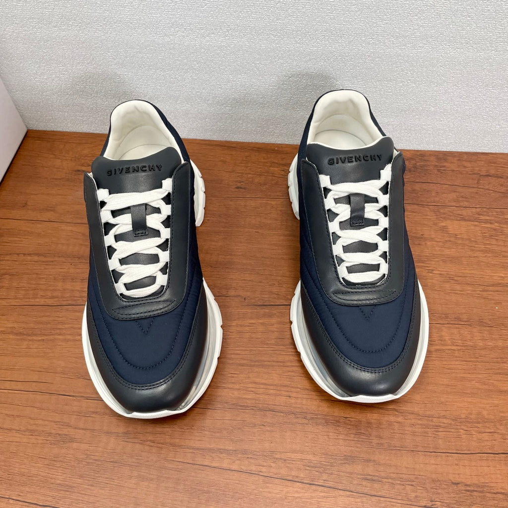 Givenchy navy low-top sneakers with white laces, padded collar, and textured sole