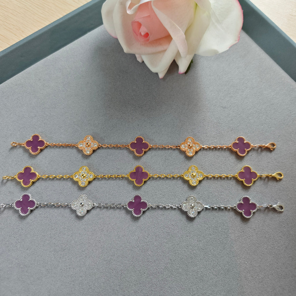 Three clover charm bracelets with purple enamel quatrefoil flowers on gold and silver chains