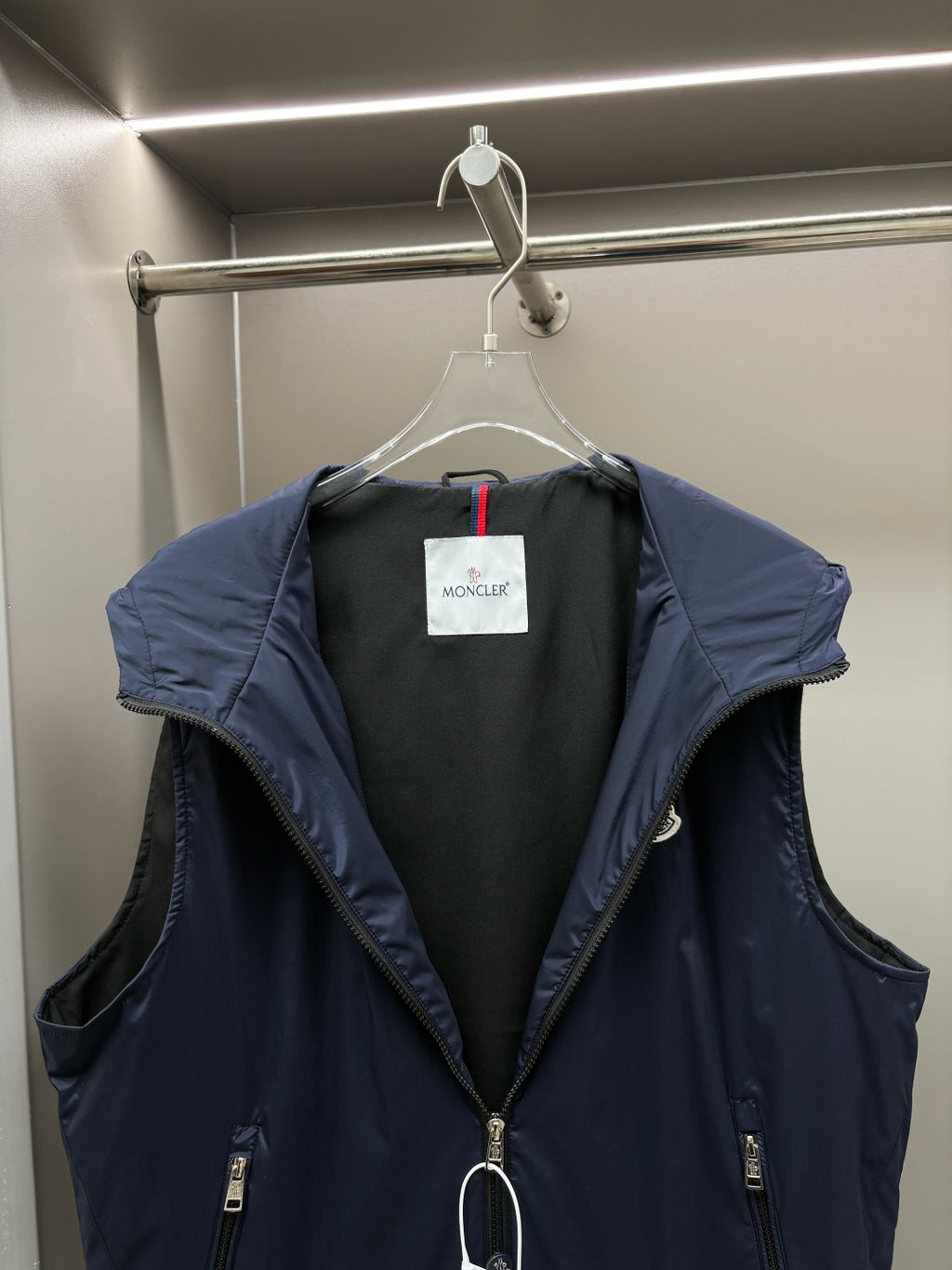 Navy hooded padded vest, front view with dark interior lining