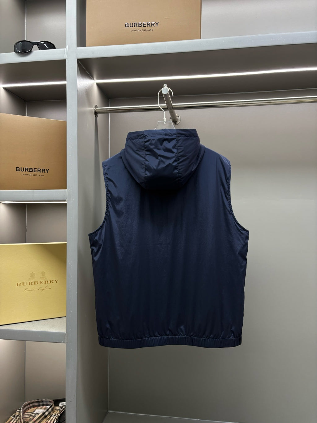 Navy hooded sleeveless vest front view on hanger with zip closure