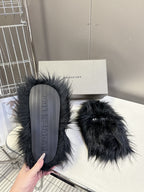 Black fuzzy slide sandals with textured rubber sole showing tread