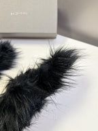 Black fuzzy slide sandal close-up with fluffy strap texture