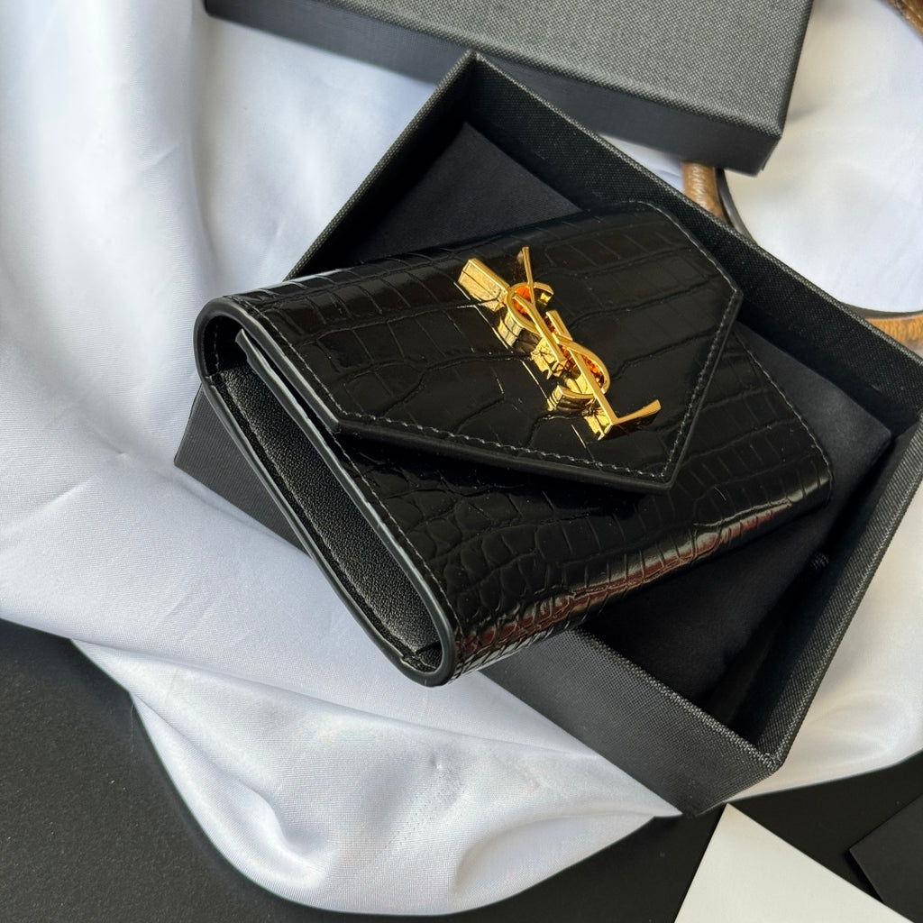 Small bag with croc-embossed black body and gold YSL logo on front flap