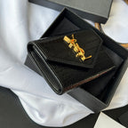 Small bag with croc-embossed black body and gold YSL logo on front flap