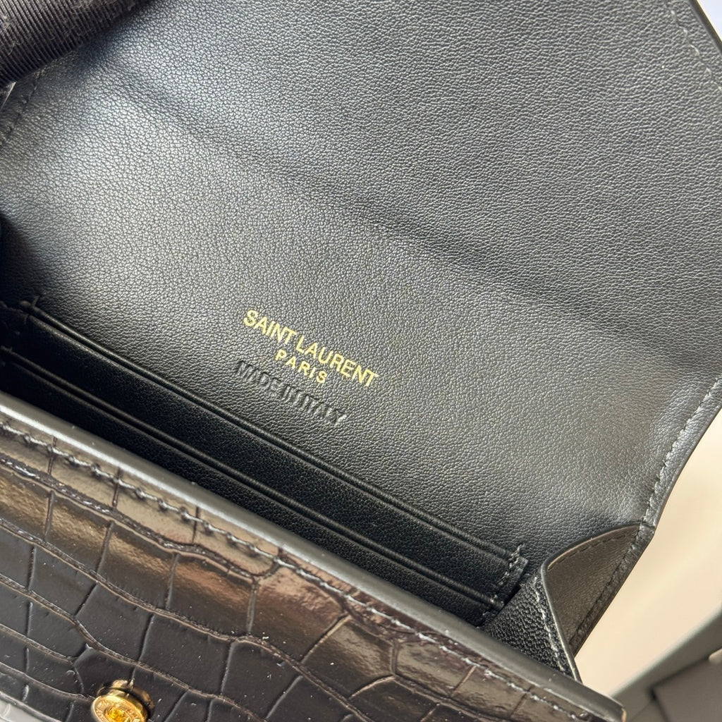 Small bag close-up of SAINT LAURENT Paris engraved logo and stitched edge seam