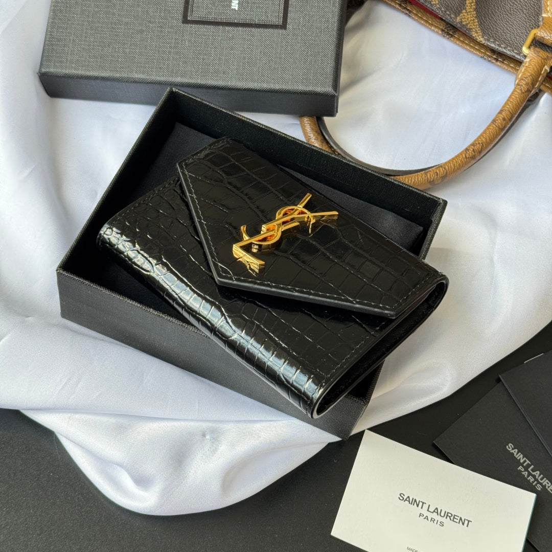 Small bag with croc-embossed black flap and gold YSL logo, shown in open gift box