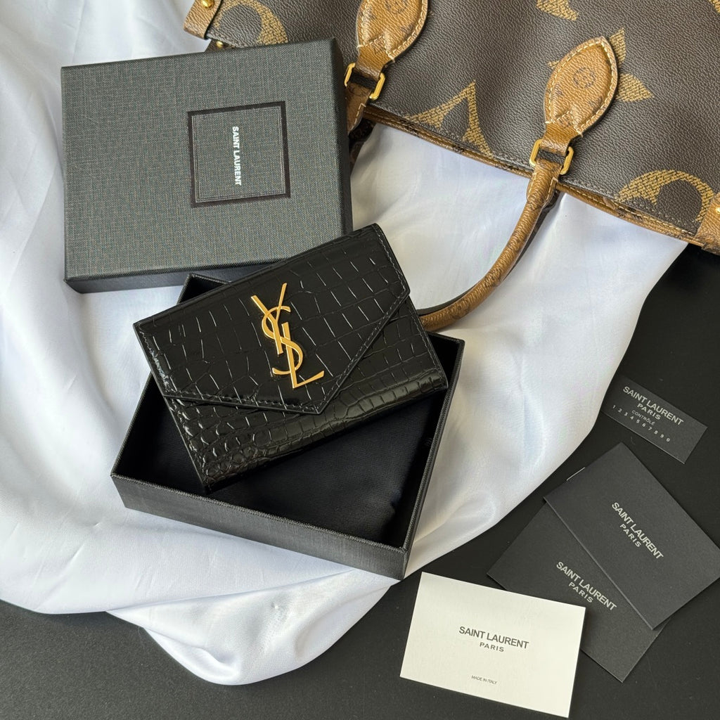 Small bag with front flap, black croc-embossed texture and gold YSL logo on cover