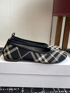 Check-print slip-on flat with pointed toe, low profile, and blue logo patch