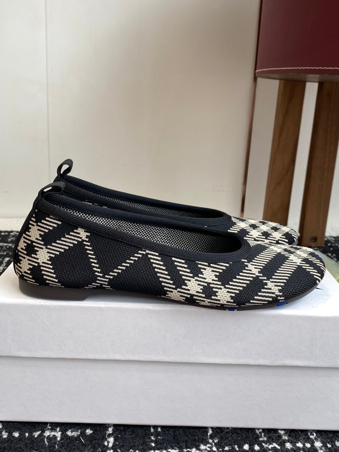 Check-print slip-on flat with pointed toe, low profile, and blue logo patch