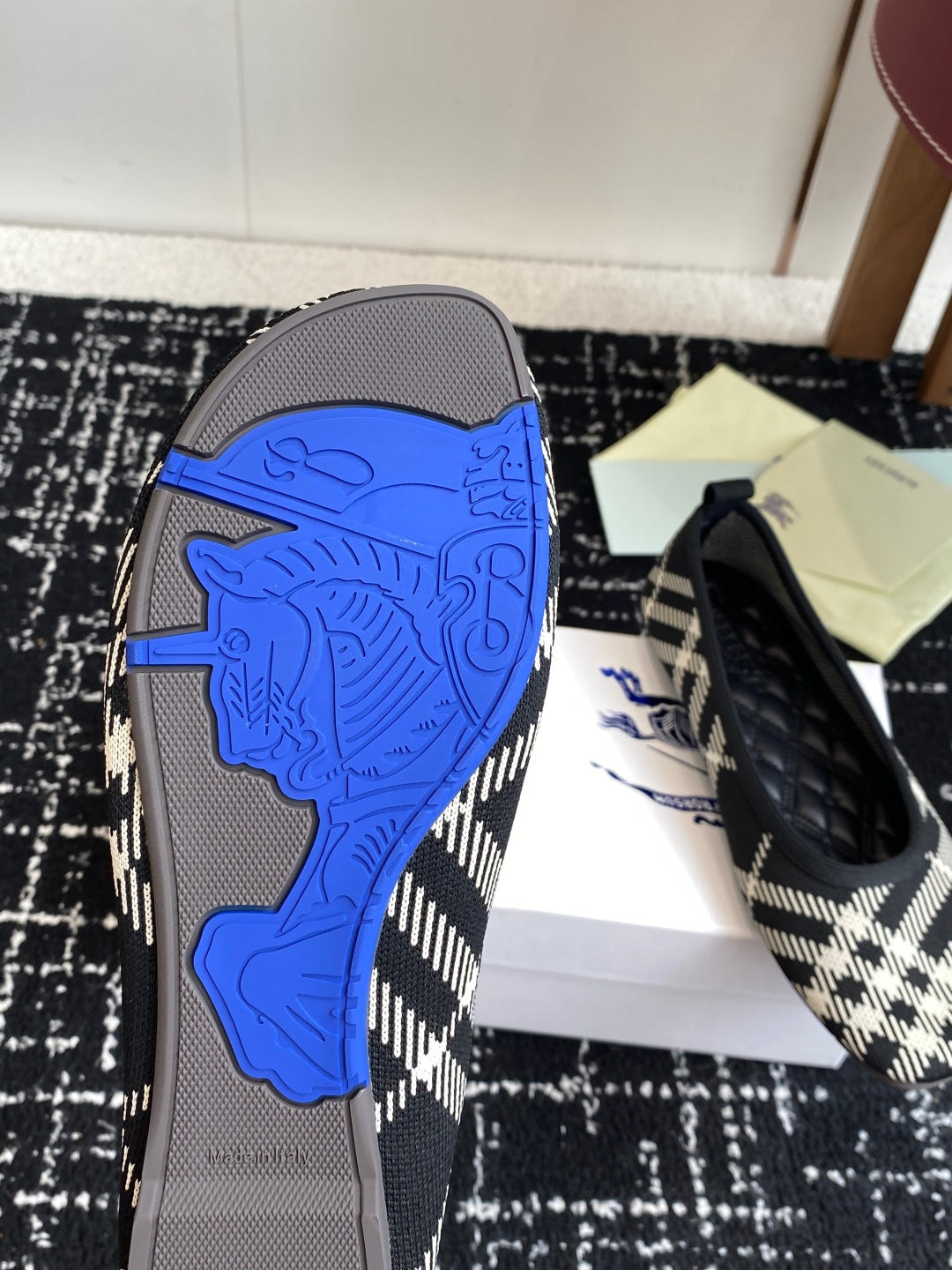 Check-print flat shoe with blue horse emblem on outsole and black rubber sole