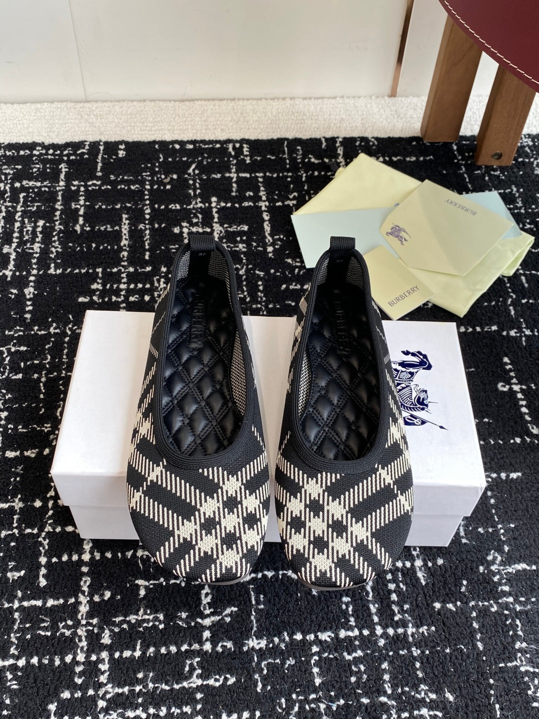 Check-print slip-on flats with black quilted toe detail and blue logo accent