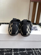 Check-print slip-on flats with black elastic heel straps and blue logo on side