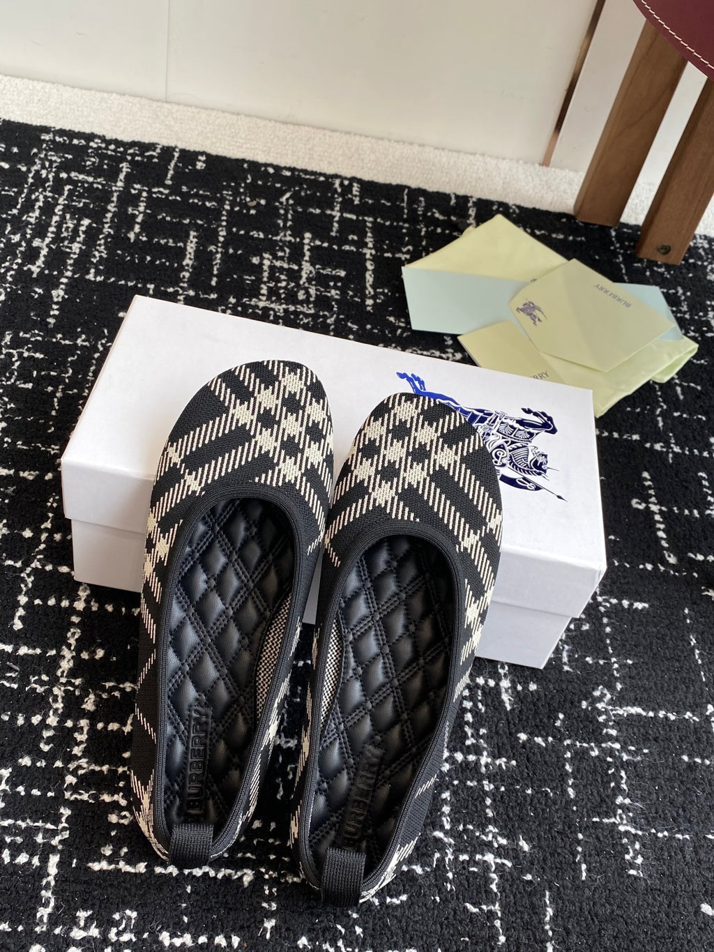 Check-print slip-on flats with black quilted uppers and blue logo stitching