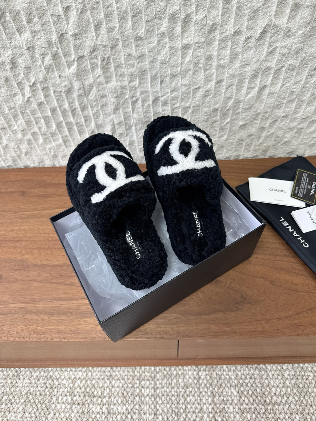 Black plush slide sandals with white double-C logo on front straps