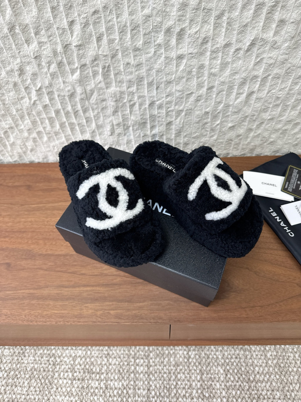 Black plush slide sandals with white double-C logo and side strap