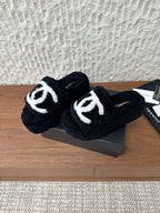 Black plush slide sandals with white logo strap detail