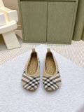 Plaid slip-on shoes with tan quilted interior, pair view on light surface
