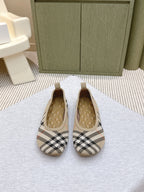 Plaid slip-on shoes with tan quilted interior, pair view on light surface